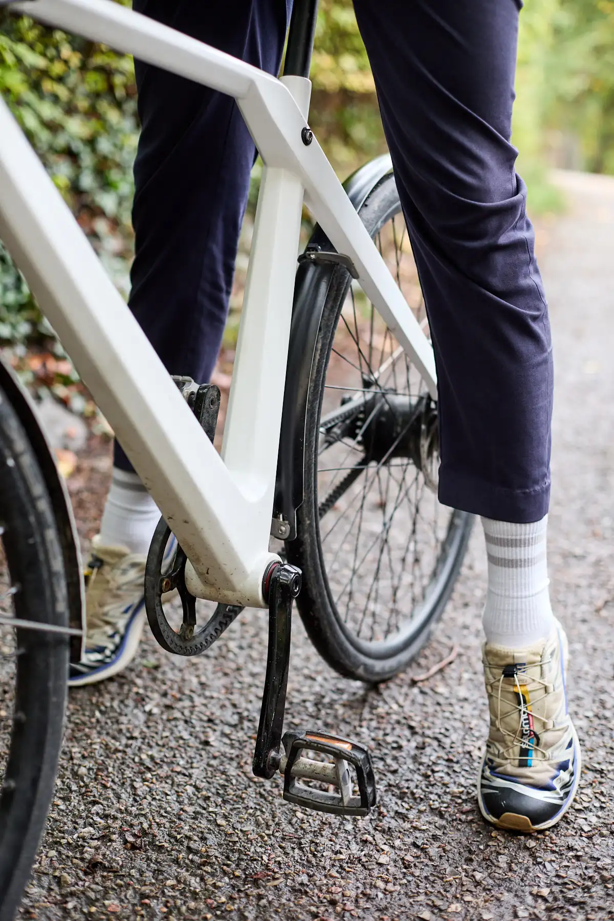 Young man standing on his toes while sitting on white Erik urban wearing Salomon sneakers in Copenhagen