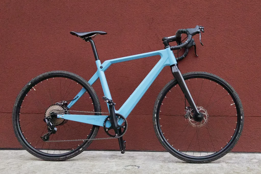 Sky blue Mattis gravel bike leaning against red wall in Copenhagen