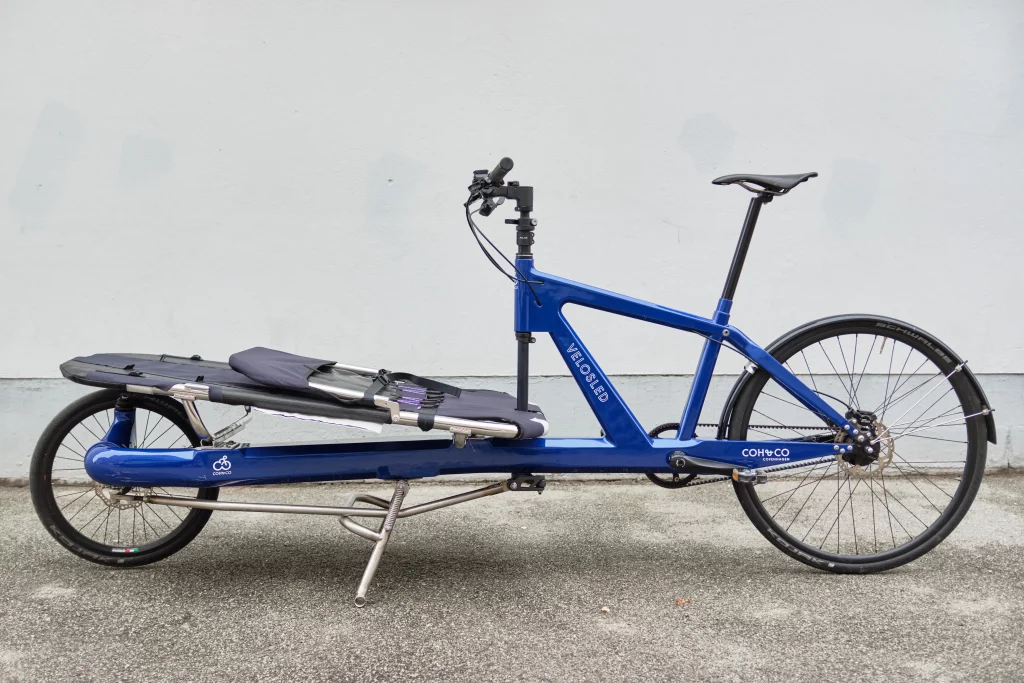 Sideview of dark blue VeloSled Anna urban cargo bike parked on the streets